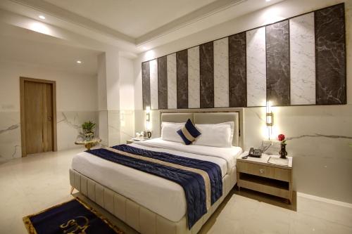 新德里Hotel Delhi 37 by Star Group NEAR DELHI AIRPORT的一间卧室配有一张大床,提供蓝白色的毯子