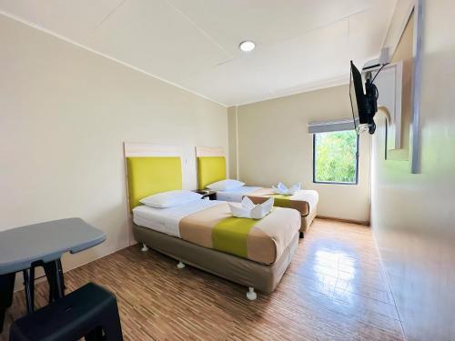 马尼拉塞勒姆DG经济型酒店的酒店客房配有两张床和一张书桌