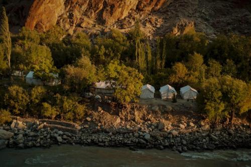 DahARYA NATURE CAMP的享有河流旁一组帐篷的空中景致