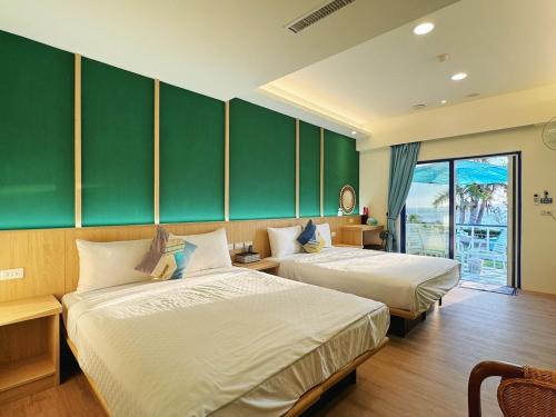 南湾黃金海岸36海景旅店的绿墙旅馆客房的两张床