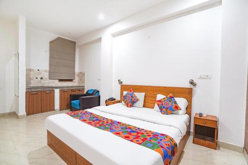 新德里FabHotel Prime Residency的一间带大床的卧室和一间厨房