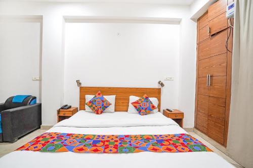 新德里FabHotel Prime Residency的一间卧室配有一张带彩色毯子的床