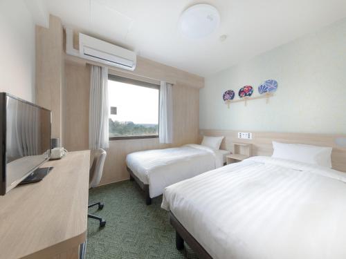 成田Tabino Hotel EXpress Narita的酒店客房设有两张床和一台平面电视。