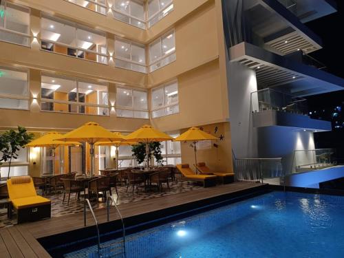 莫尔穆冈Regenta Place Vasco Goa的一座设有台球桌和黄伞的酒店