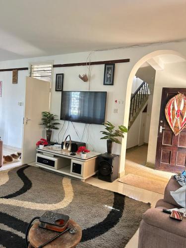 蒙巴萨Mopearlz 4bedroom villa Nyali的客厅配有平面电视和沙发。