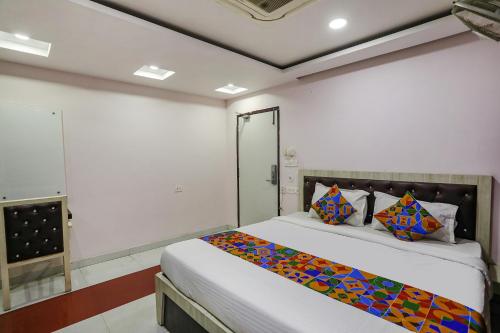 勒克瑙FabHotel Leaf Paradise的一间卧室配有一张带彩色毯子的床