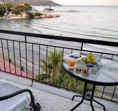 阿吉亚玛丽娜斯韦特兰娜&米哈利斯绿洲大酒店的俯瞰大海的阳台桌子上的食品托盘