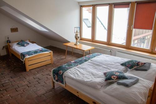 捷克布杰约维采Podkroví v Kabinetu CB的阁楼卧室设有两张床和窗户。