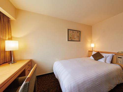 大阪大阪守口丽都大酒店的配有一张床和一张书桌的酒店客房
