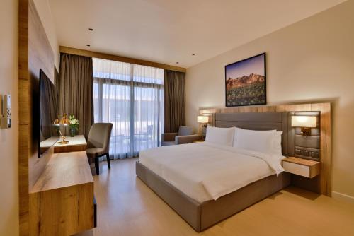欧拉Cloud 7 Residence AlUla的酒店客房设有一张大床和一张书桌。