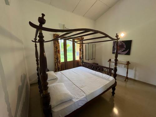 库鲁内格勒Rivendell Twisted Tree的卧室配有带白色床单的天蓬床