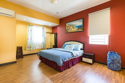 峇六拜Cosy HomeStay at Penang Island -Beach and Village的卧室设有红色的墙壁和一张床