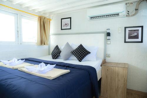 纳闽巴霍Arimbi Liveaboard的一间卧室配有蓝色的床和2条毛巾