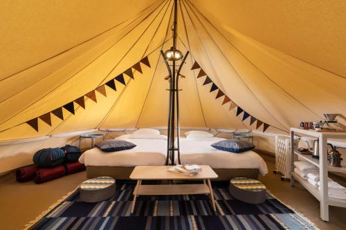 白马村Laforet Glamping Field Hakuba的帐篷配有两张床和一张桌子