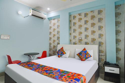 巴特那FabHotel Raj Niwas的卧室配有白色的床和蓝色的墙壁