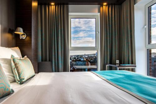 泰恩河畔纽卡斯尔纽卡斯尔一号酒店的一间卧室设有一张大床和一个窗户。