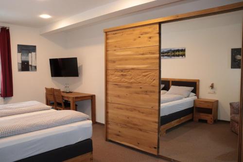 RöthenbachLandgasthof Post的一间带两张床和大型木制橱柜的卧室
