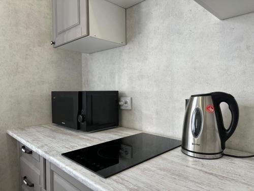 科克舍套ЖК Ауэзова1的厨房柜台配有微波炉和烤面包机。