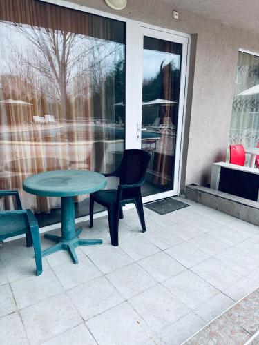 阳光海滩Stella Udacha Apartments & Studios的一个带桌椅的庭院和一个窗户。