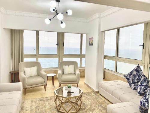 亚历山大Alexandria Luxury Apartments Stanley Direct Sea View的客厅配有沙发、两把椅子和一张桌子
