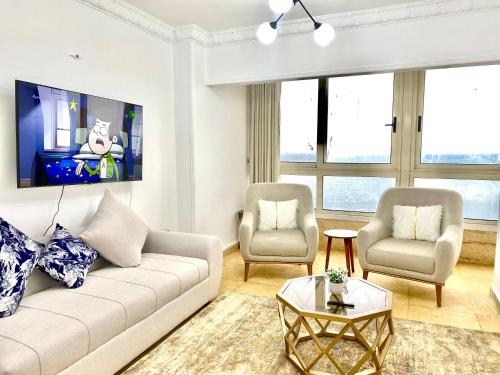 亚历山大Alexandria Luxury Apartments Stanley Direct Sea View的客厅配有沙发和两把椅子