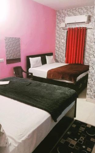 AyodhyaPremshi Guest House的配有粉红色墙壁的客房内的两张床