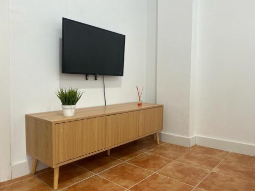 巴达霍斯Apartamento Valdepasillas的木制橱柜顶部的平面电视