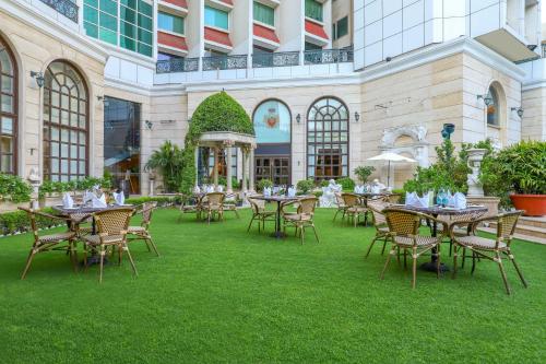 新德里皇家广场酒店的室外庭院在草地上配有桌椅