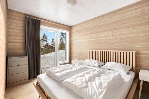 弗罗达尔Moderne hytte met eindeloos uitzicht en een sauna的一间卧室设有一张大床和一个窗户。