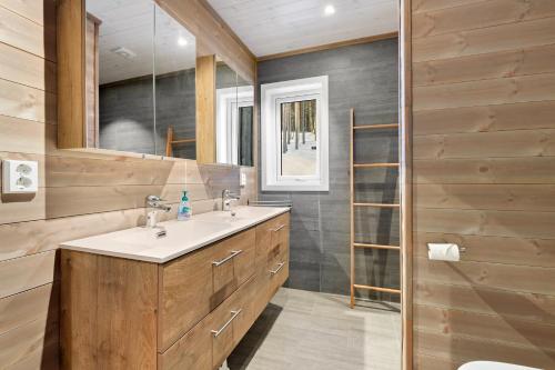 弗罗达尔Moderne hytte met eindeloos uitzicht en een sauna的一间带水槽和镜子的浴室