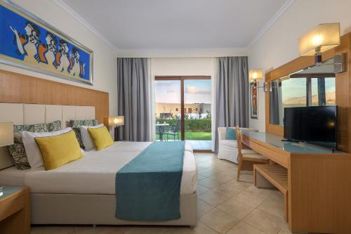 吉奥塔略林多斯帝国水疗度假村的酒店客房配有一张床、一张书桌和一台电视。