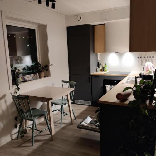 卡伯尔沃格Nybygget leilighet i Kabelvåg的厨房配有桌子和桌椅
