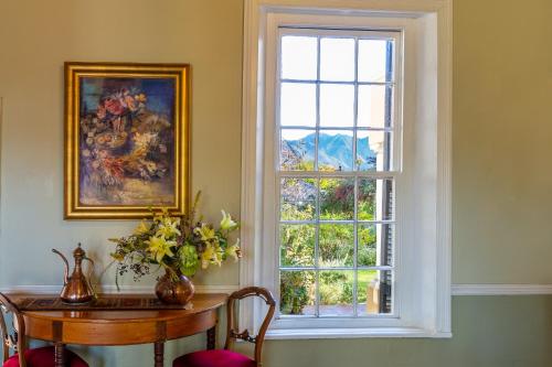 乔治迪瓦恩维斯旅馆的窗户位于带桌椅和桌子的木桌的客房内。