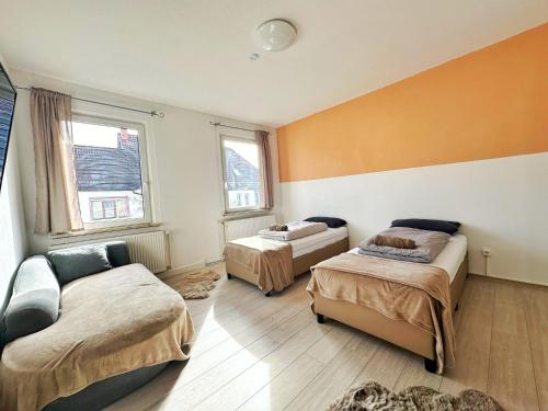 菲林根-施文宁根Cozy Vacations Home in the Black Forest的客房设有两张床、一张沙发和两个窗户。