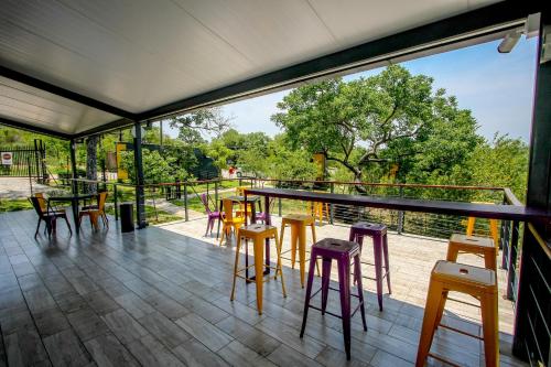 斯库库扎SleepOver Kruger Gate的阳台配有凳子和桌子,享有树木的景致。