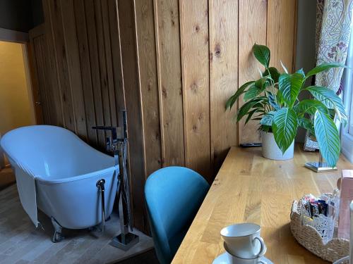 卡伦普顿The Roost的一间设有桌子、椅子和植物的房间