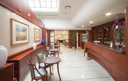 西维尔诺瓦·马尔凯皇宫酒店的餐厅设有酒吧,配有桌椅