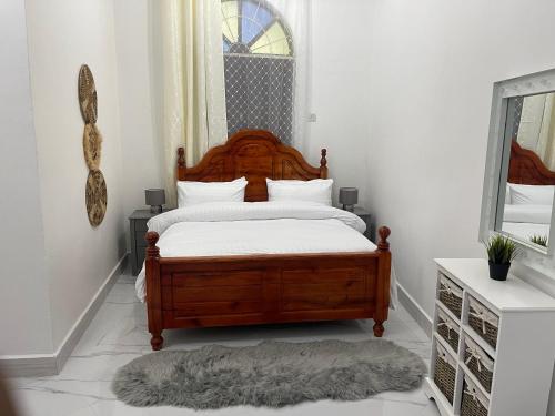 NgamboNashu House Stone Town的一间卧室设有一张木床和一个窗户。