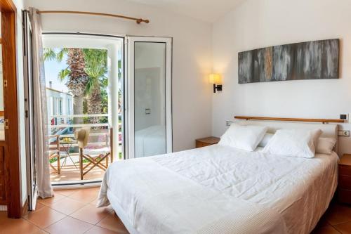 萨卡莱塔Villa Blanc的一间带白色床的卧室和一个阳台