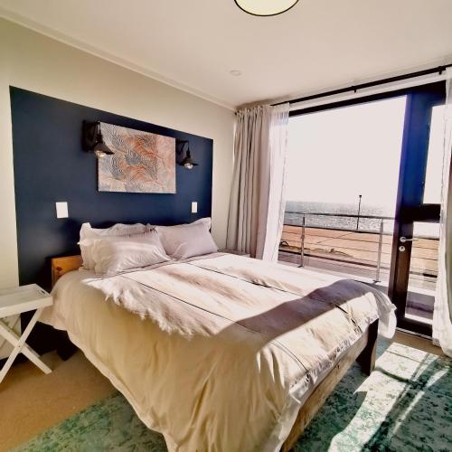 鲸湾港Beachfront Townhouse - MowenOne的一间卧室设有一张大床和一个大窗户