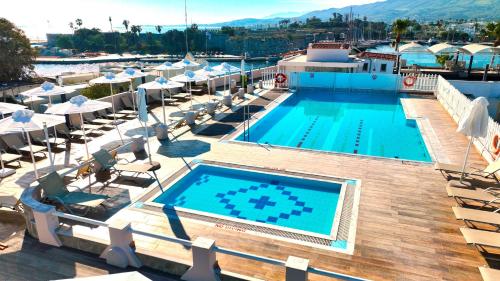 科斯镇科斯塔宫酒店的一个带躺椅的游泳池,一个度假村