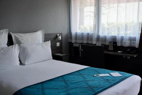比亚里茨Sure Hotel by Best Western Biarritz Aeroport的一间卧室配有一张床、一张书桌和一个窗户。