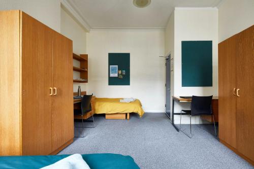伦敦Campbell House的一间卧室配有一张床、一张桌子和一张四柱床。