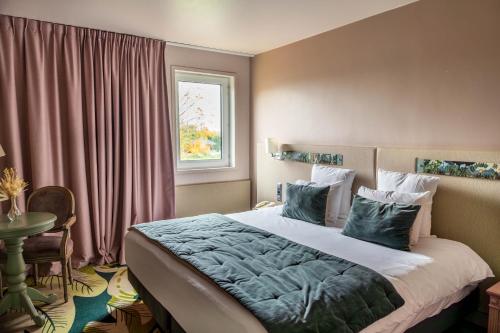 勒库德雷·蒙特考克斯Mercure Parc du Coudray - Barbizon的一间卧室设有一张大床和一个窗户。