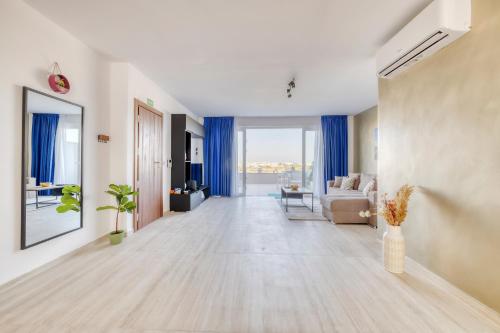 Hal GhaxiakSalmar Court Holiday Apartments的客厅配有蓝色窗帘和沙发