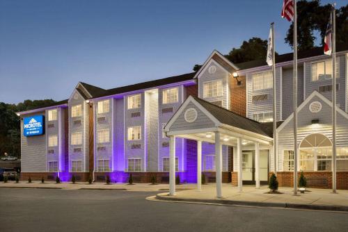 罗利温德姆不伦瑞克省麦克罗套房酒店的一座大建筑前面有紫色的灯