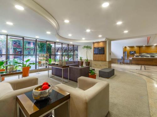 库里提巴库里提巴金色美居酒店 的客厅配有沙发、椅子和桌子
