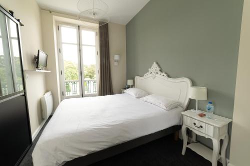 拉贝尔讷里昂雷茨Domaine de La Gressière的卧室设有一张白色大床和一扇窗户。
