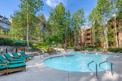 惠斯勒Hilton Grand Vacations Club Whistler的一个带躺椅的游泳池和一个庭院