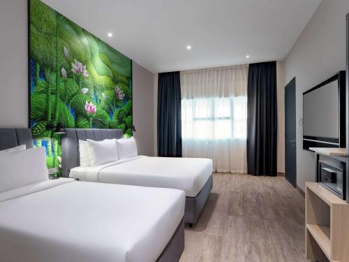雪邦ibis Styles Sepang KLIA的一间酒店客房,设有两张床和电视
